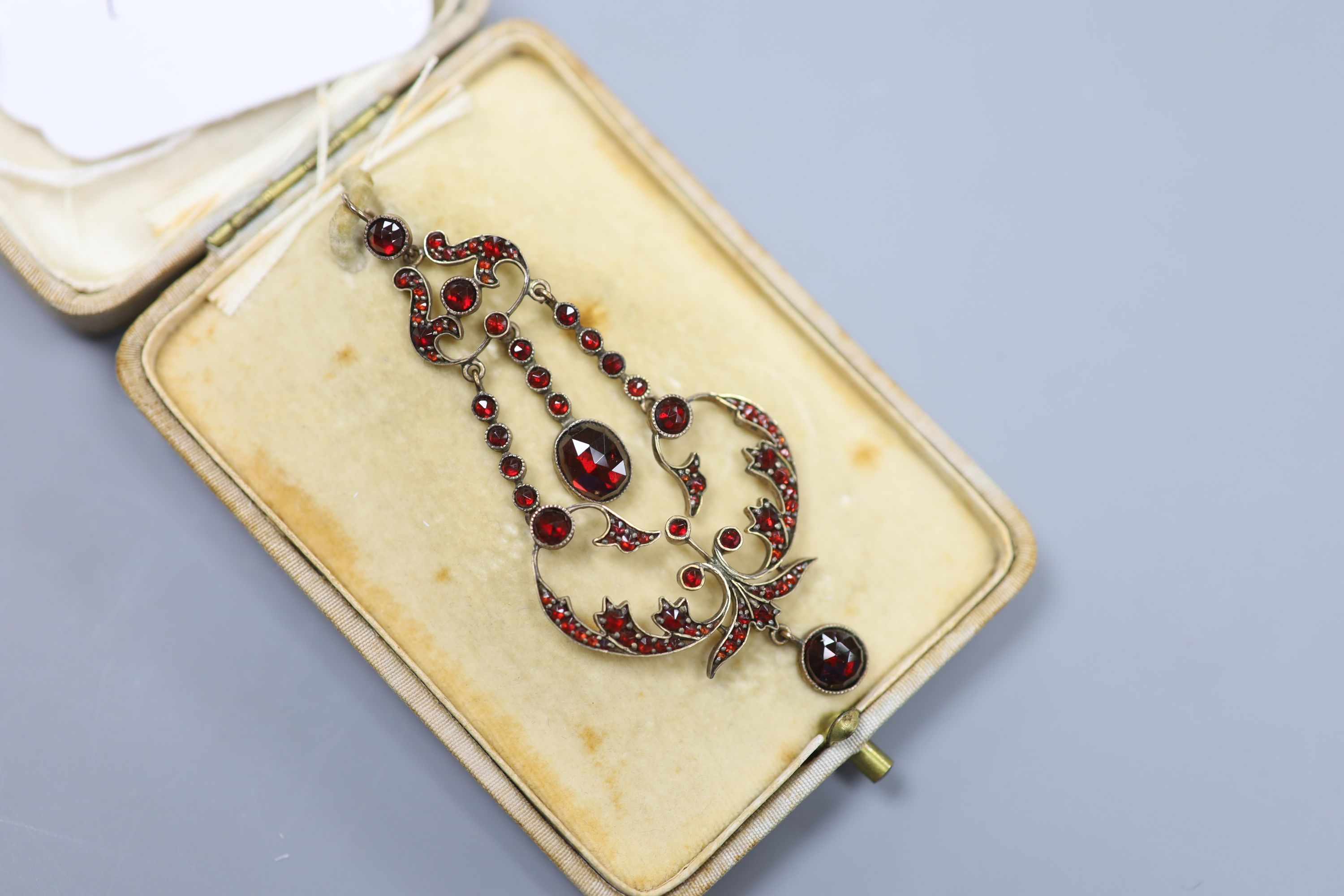 A late Victorian gold plated and facet garnet garnet cluster set drop pendant, overall 75cm, 6.9 grams.